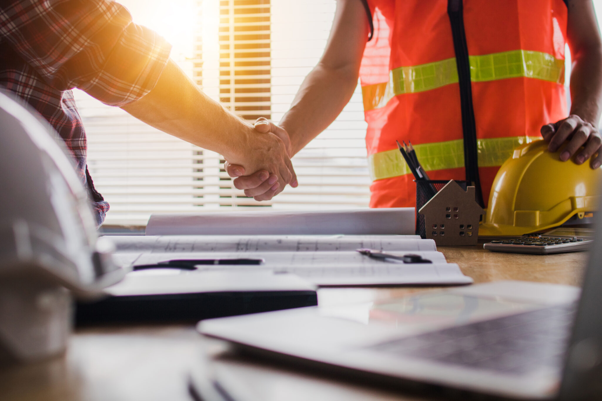 Handshake of tradie and broker signing finance documents for loan